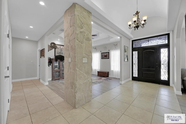 tiled entrance foyer with an inviting chandelier