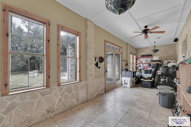 interior space featuring ceiling fan and plenty of natural light