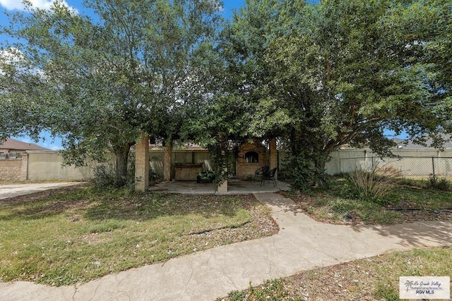 obstructed view of property with a front lawn and a patio