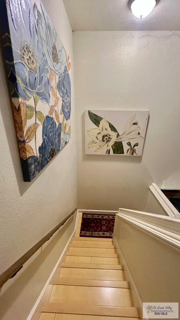 staircase with baseboards and wood finished floors