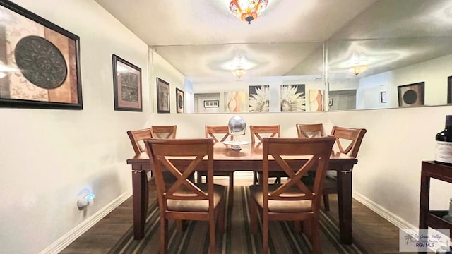 dining space with baseboards and wood finished floors