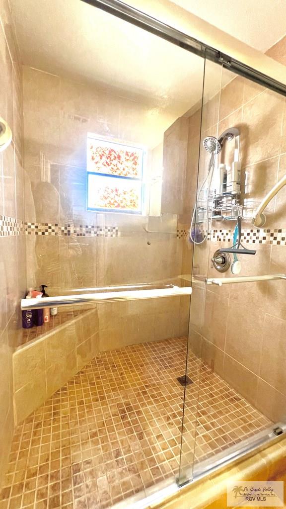 bathroom with tile patterned floors and tiled shower