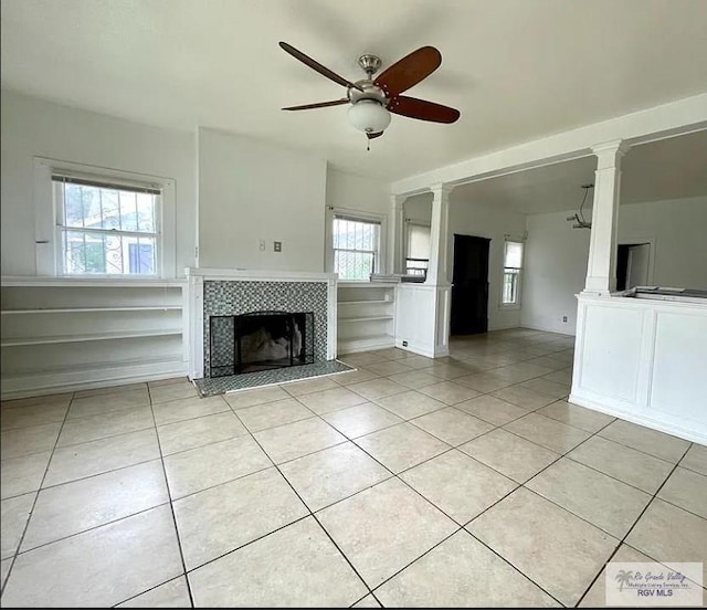 unfurnished living room featuring light tile patterned flooring, ceiling fan, and a tiled fireplace