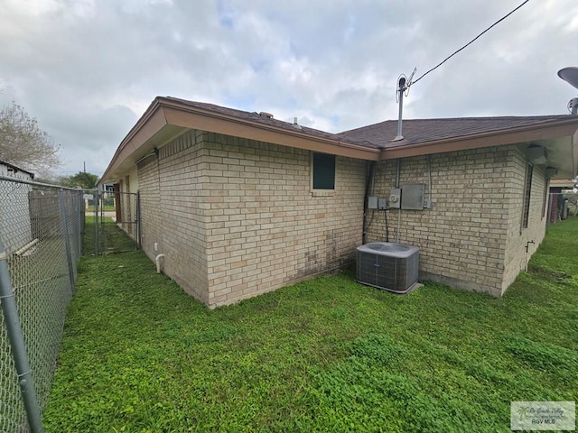 view of side of home featuring a lawn and central air condition unit