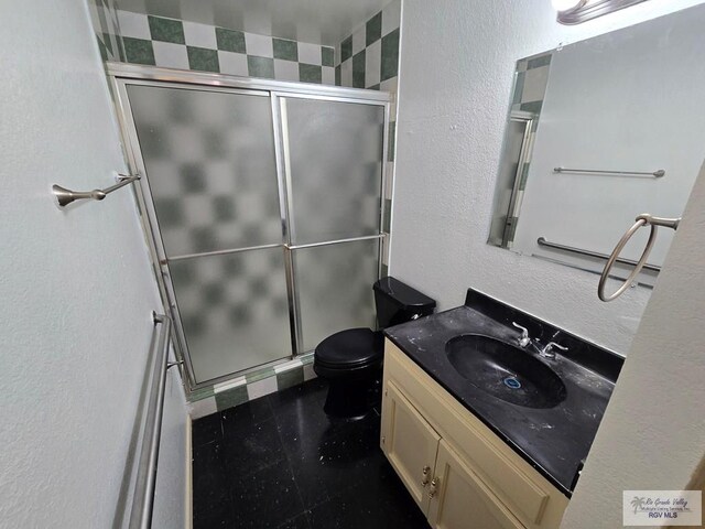 bathroom with vanity, toilet, and a shower with shower door