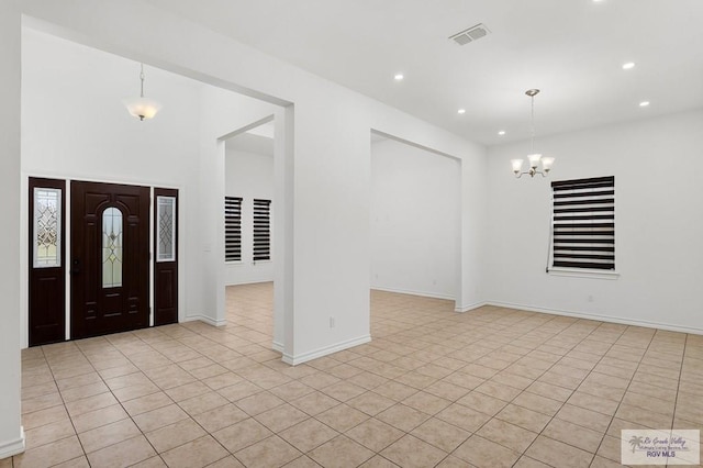 entryway with light tile patterned floors and a chandelier