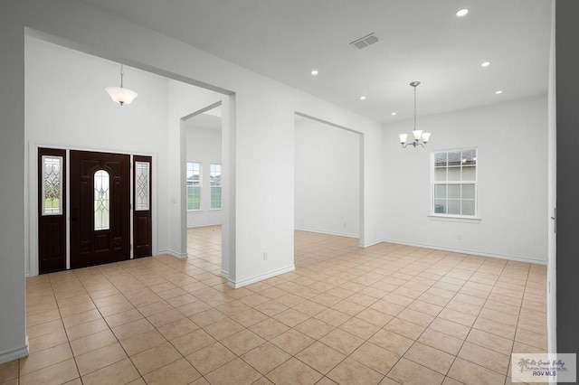 entryway with a notable chandelier and light tile patterned floors