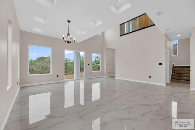 unfurnished room featuring high vaulted ceiling and a notable chandelier