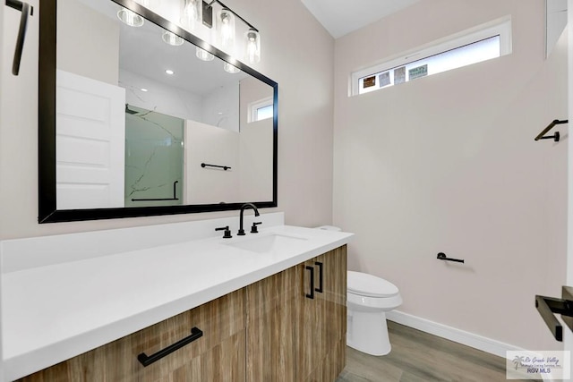 bathroom with a shower, hardwood / wood-style floors, vanity, and toilet