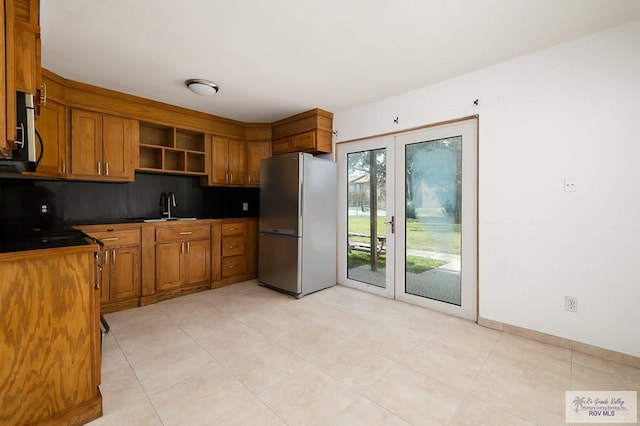 kitchen featuring decorative backsplash, sink, stainless steel appliances, and french doors