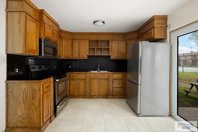 kitchen featuring light tile patterned flooring, stainless steel appliances, tasteful backsplash, and sink