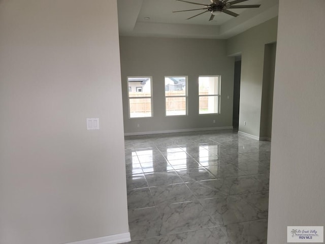 4806 Holly Ann St, Harlingen, TX 78552 - unfurnished room with marble finish floor, a tray ceiling, a high ceiling, baseboards, and ceiling fan