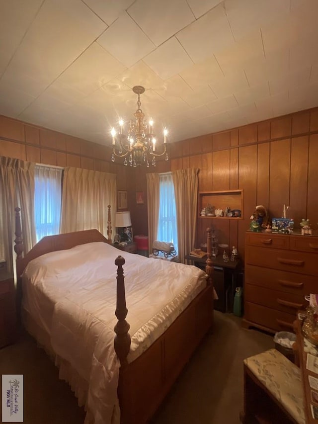 carpeted bedroom with wood walls and an inviting chandelier