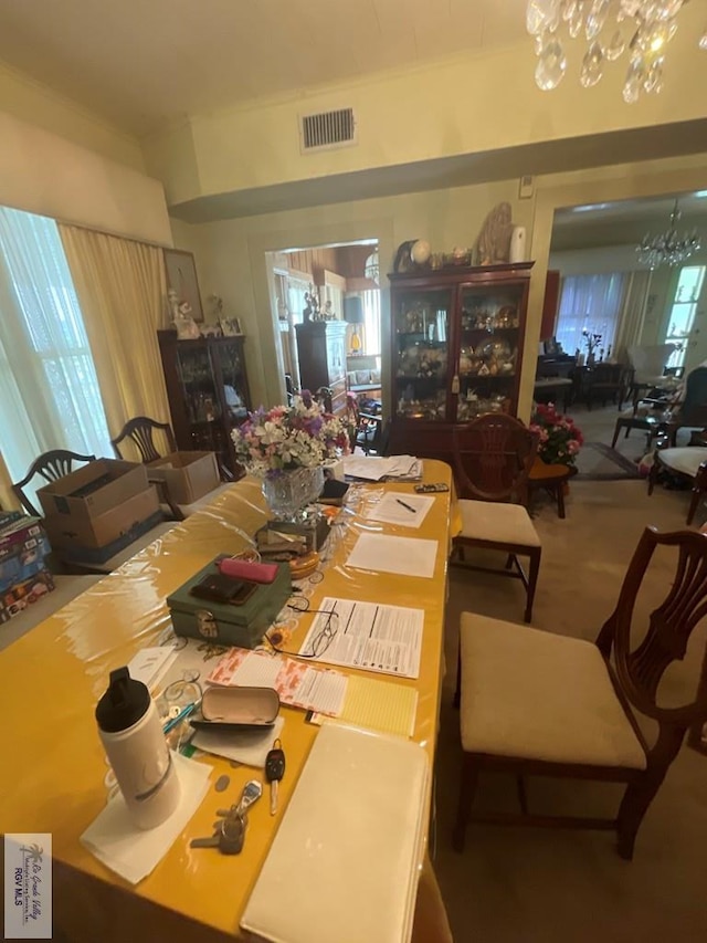 dining area with carpet floors and a notable chandelier