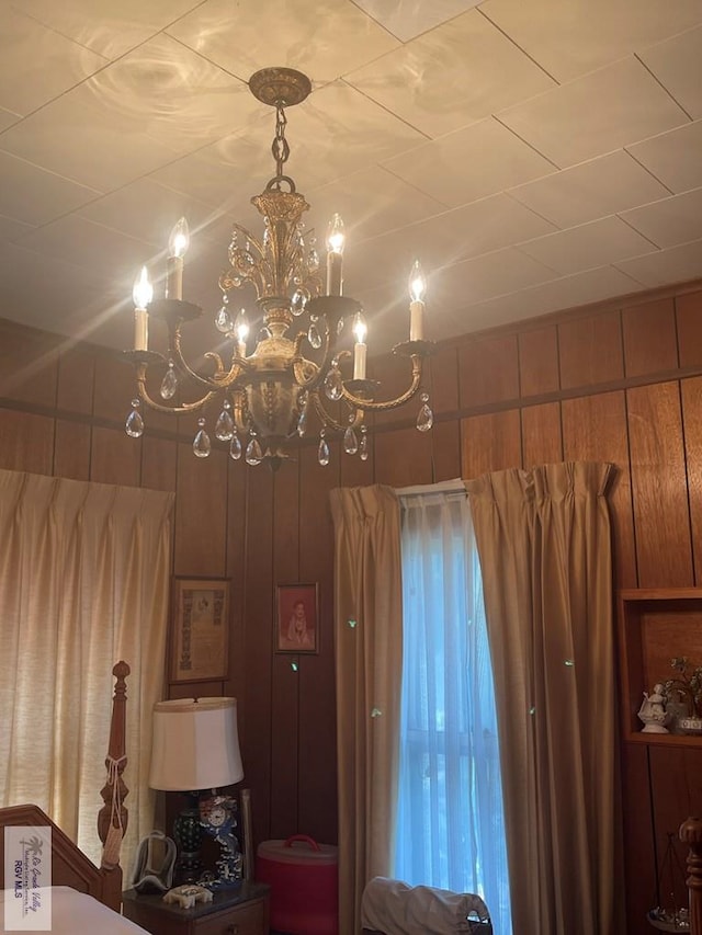 unfurnished bedroom with wooden walls and an inviting chandelier