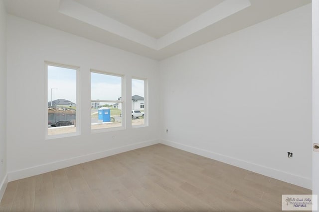 8830 Wentz Lk, Brownsville, TX 78520 - empty room with light wood-style floors, baseboards, and a tray ceiling