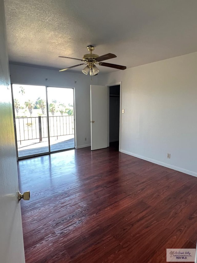 empty room featuring ceiling fan, dark hardwood / wood-style flooring, and a textured ceiling