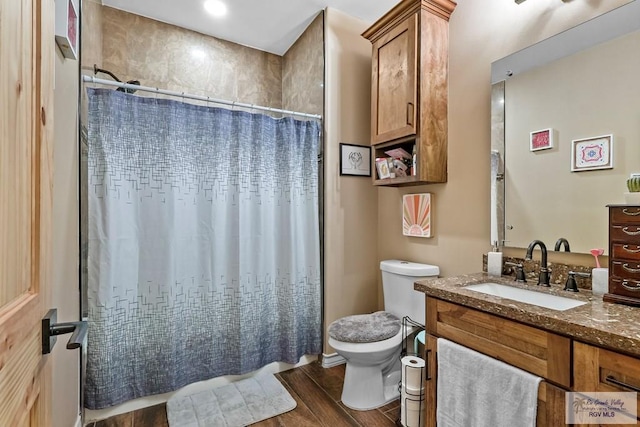 bathroom with hardwood / wood-style floors, vanity, toilet, and a shower with curtain