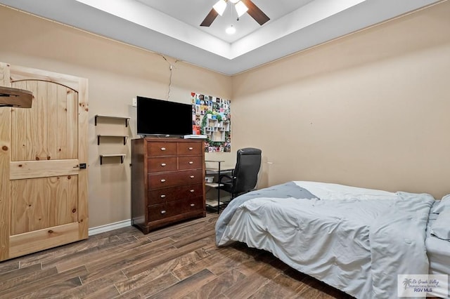 bedroom featuring a tray ceiling, ceiling fan, and hardwood / wood-style flooring