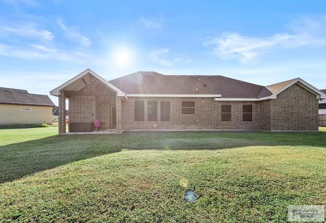 rear view of house featuring a yard