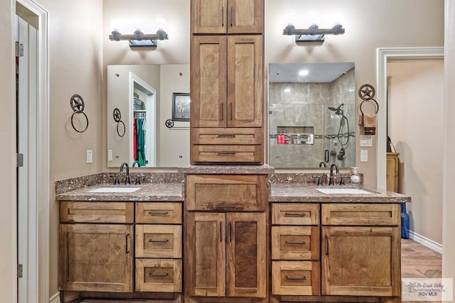 bathroom featuring a tile shower, vanity, and hardwood / wood-style flooring