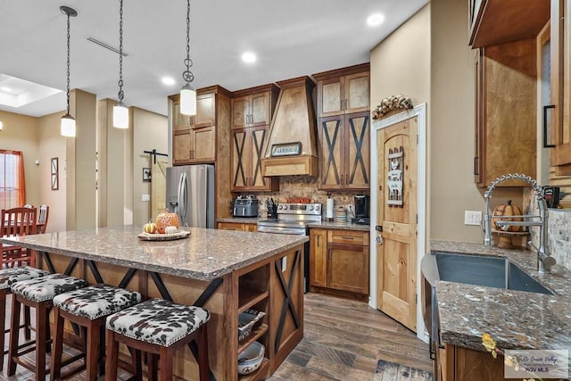 kitchen featuring a center island, stainless steel appliances, dark wood-type flooring, and dark stone countertops