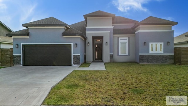 prairie-style home featuring a front yard, stucco siding, concrete driveway, a garage, and stone siding