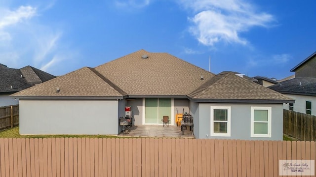 back of house featuring a patio area, fence, roof with shingles, and stucco siding