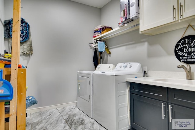 clothes washing area with washing machine and clothes dryer, baseboards, cabinet space, marble finish floor, and a sink