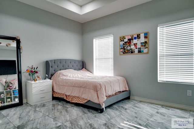 bedroom featuring multiple windows, baseboards, and marble finish floor