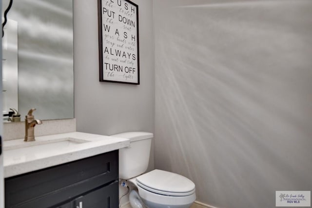 half bathroom featuring toilet and vanity