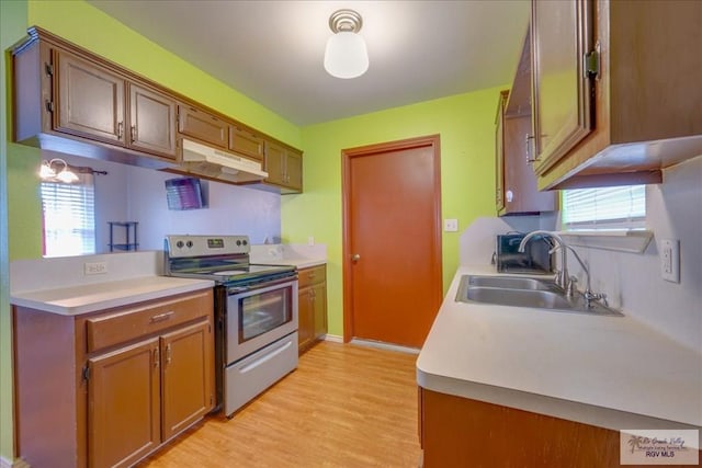 1137 Julissa Dr, Los Fresnos, TX 78566 - kitchen featuring light wood-style flooring, under cabinet range hood, stainless steel electric range, a sink, and light countertops