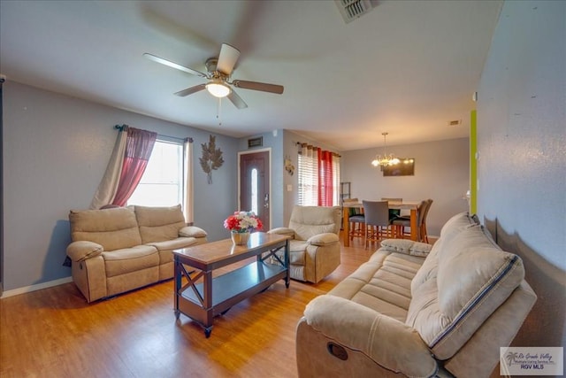 1137 Julissa Dr, Los Fresnos, TX 78566 - living room with a wealth of natural light, visible vents, ceiling fan with notable chandelier, and light wood-style floors