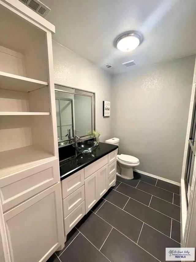 bathroom with tile patterned flooring, vanity, and toilet