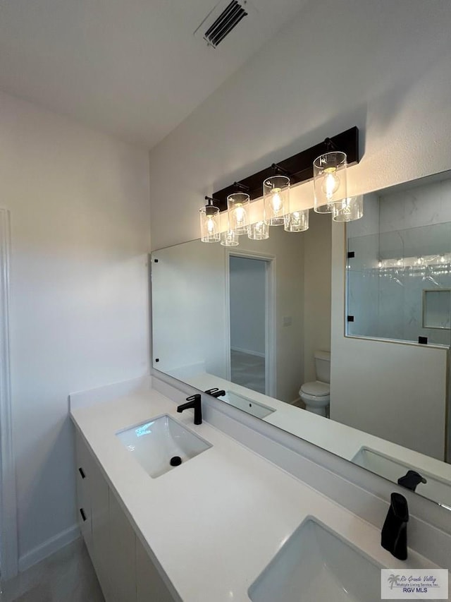 bathroom with vanity, toilet, and a shower