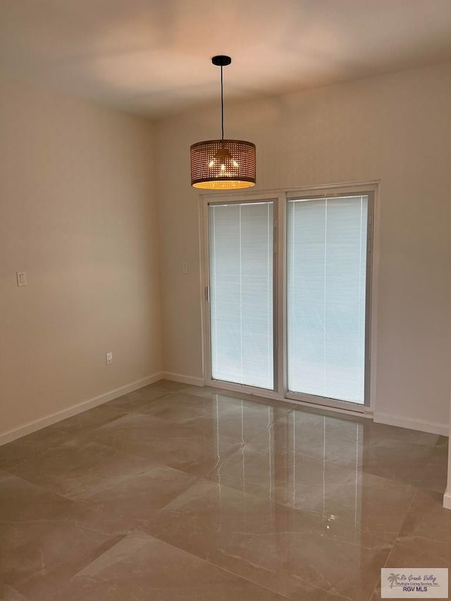 unfurnished room featuring a notable chandelier