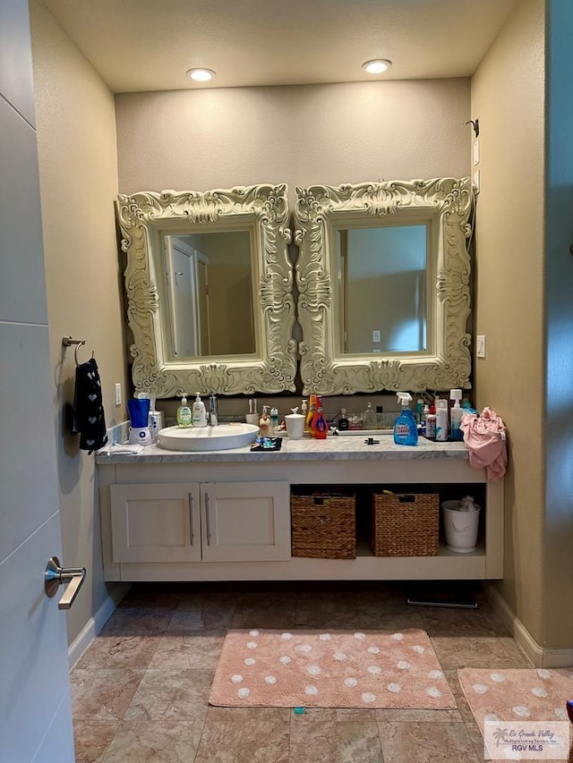 6200 Rio Sena St, Brownsville, TX 78526 - bathroom with vanity, baseboards, and stone finish flooring