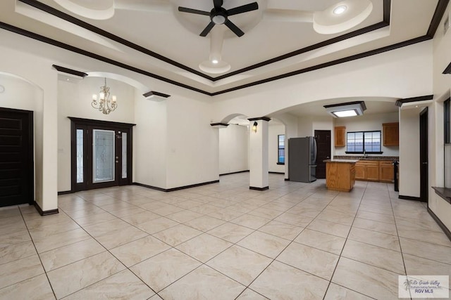 6705 Stone Oak Dr, Brownsville, TX 78526 - unfurnished living room featuring a raised ceiling, a ceiling fan, a chandelier, ornamental molding, and arched walkways
