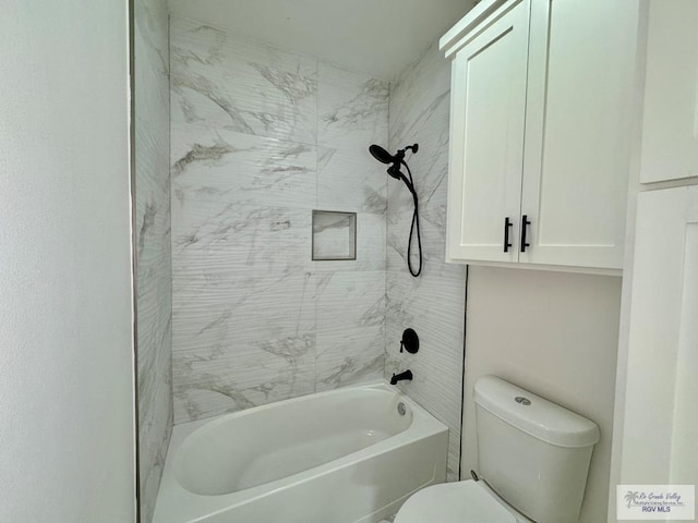 bathroom featuring tiled shower / bath combo and toilet