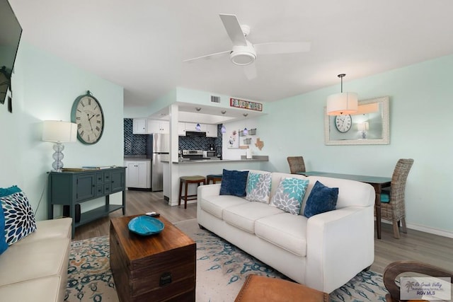 living room with hardwood / wood-style floors and ceiling fan