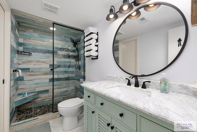 bathroom with vanity, toilet, and a shower with door