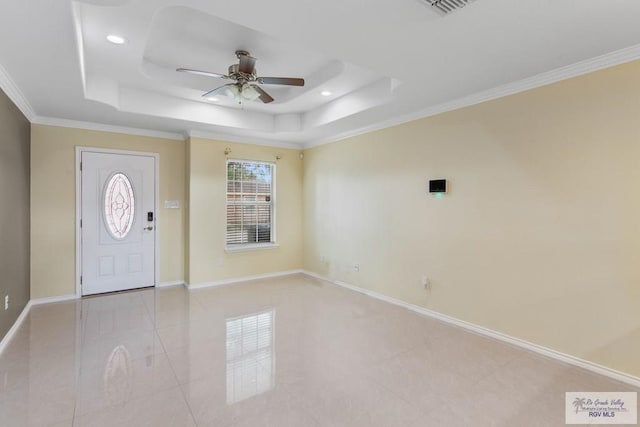 entrance foyer featuring a raised ceiling, ceiling fan, and ornamental molding