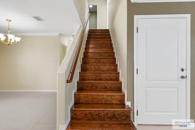 staircase with tile patterned flooring, crown molding, and a notable chandelier