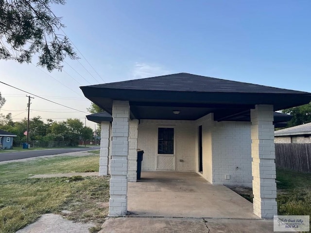 exterior space with a carport and a lawn