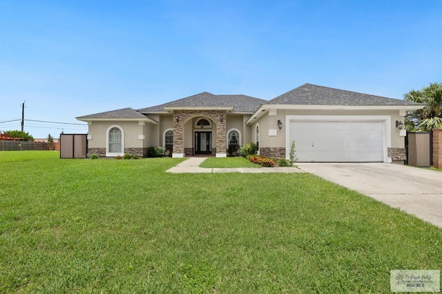 3271 Emerald Valley Blvd Unit 8, Brownsville, TX 78526 - view of front of property with stone siding, stucco siding, an attached garage, concrete driveway, and a front yard
