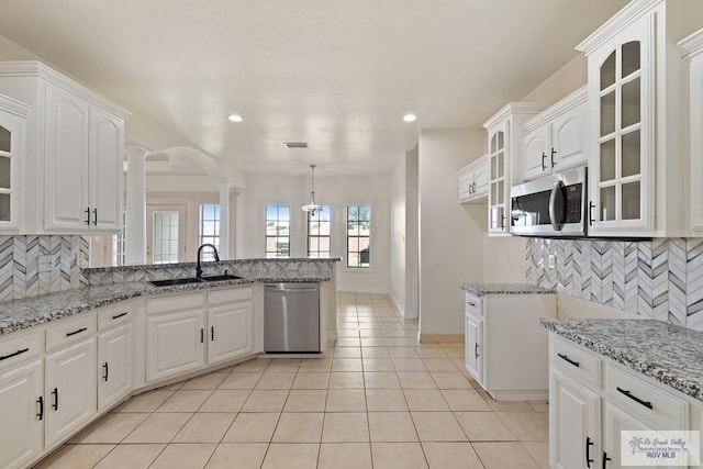 3271 Emerald Valley Blvd Unit 8, Brownsville, TX 78526 - kitchen featuring appliances with stainless steel finishes, decorative columns, glass insert cabinets, light tile patterned flooring, and recessed lighting