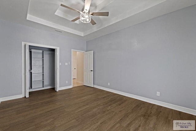 3271 Emerald Valley Blvd Unit 8, Brownsville, TX 78526 - unfurnished bedroom with a tray ceiling, dark wood finished floors, ceiling fan, and a closet