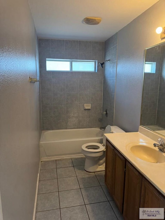 full bathroom with tile patterned flooring, vanity, tiled shower / bath combo, and toilet