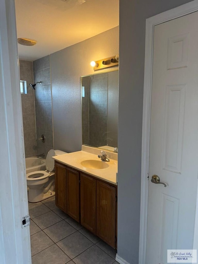 full bathroom featuring tile patterned floors, vanity, toilet, and tiled shower / bath combo