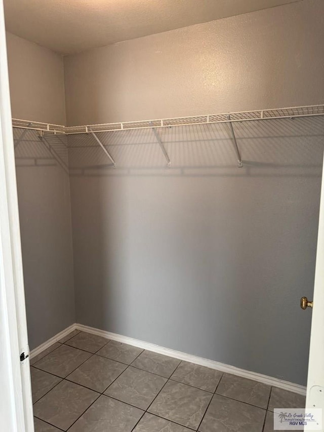 walk in closet with tile patterned flooring